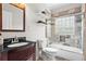 Bathroom displays dark vanity, glass enclosed tiled shower over tub and floating shelves at 176 Ormond Se St, Atlanta, GA 30315