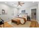 Bright bedroom features hardwood floors, ceiling fan, large bed, and ensuite bath at 176 Ormond Se St, Atlanta, GA 30315