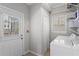Laundry room with washer, dryer, utility sink, white cabinets and access to the back yard at 176 Ormond Se St, Atlanta, GA 30315