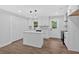 Bright kitchen with white cabinets, a kitchen island, and modern lighting fixtures at 2326 Brackett Sw St, Marietta, GA 30060