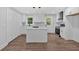 Bright kitchen features an island, white cabinets, stainless steel appliances, and wooden floors at 2326 Brackett Sw St, Marietta, GA 30060