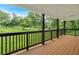 An inviting covered porch with wood flooring and dark pillars showcases lovely landscape views at 2326 Brackett Sw St, Marietta, GA 30060