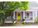 Charming home featuring a bright yellow door, lilac exterior paint, and a welcoming front porch with a seating area at 611 Pickett Se St, Atlanta, GA 30316