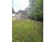 Spacious backyard with a gentle slope and lush green grass, perfect for outdoor activities at 5388 Robertson Path, Lithonia, GA 30038