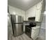 Bright kitchen features white cabinetry, modern appliances, and new grey wood flooring at 5388 Robertson Path, Lithonia, GA 30038