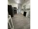 Bright kitchen features white cabinetry, modern appliances, and new grey wood flooring at 5388 Robertson Path, Lithonia, GA 30038