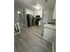 Bright kitchen features white cabinetry, modern appliances, and new grey wood flooring at 5388 Robertson Path, Lithonia, GA 30038