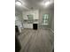 Modern kitchen with white cabinets, gray backsplash, and laminate flooring, perfect for cooking at 5388 Robertson Path, Lithonia, GA 30038