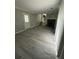 Large living room with fireplace, lots of light, and new grey wood flooring at 5388 Robertson Path, Lithonia, GA 30038