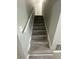 A view of a staircase with light gray wood steps, gray walls, and white handrail, leading to the upper level at 5388 Robertson Path, Lithonia, GA 30038