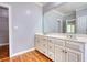 Bathroom with double sinks, a large vanity, and a large mirror stretching across the wall at 80 Surrey Chase Drive, Social Circle, GA 30025
