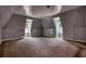 Spacious bonus room with angled ceilings, carpeted floors, and two windows for natural light at 80 Surrey Chase Drive, Social Circle, GA 30025