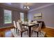 Dining room featuring hardwood floors, natural light, and a stylish chandelier at 80 Surrey Chase Drive, Social Circle, GA 30025