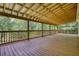 Large, covered wooden porch overlooking the wooded backyard, creating a serene outdoor space at 80 Surrey Chase Drive, Social Circle, GA 30025