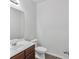 Neat half bathroom with a dark wood vanity and white fixtures at 1099 Sandy Bank Ct, Auburn, GA 30011