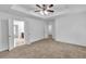 Bedroom featuring a tray ceiling and access to additional rooms at 1099 Sandy Bank Ct, Auburn, GA 30011