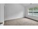 Bright bedroom featuring a window offering natural light and neutral carpet flooring at 1099 Sandy Bank Ct, Auburn, GA 30011