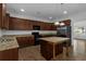 Modern kitchen with granite countertops, central island, stainless steel refrigerator, and dark cabinets at 1099 Sandy Bank Ct, Auburn, GA 30011