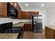 Modern kitchen featuring stainless steel appliances, granite countertops, and dark wood cabinets at 1099 Sandy Bank Ct, Auburn, GA 30011