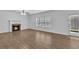Spacious living room with a corner fireplace and a large window overlooking the backyard at 1099 Sandy Bank Ct, Auburn, GA 30011