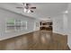 Bright living room featuring wood-look floors, ceiling fan, and multiple windows for ample natural light at 1099 Sandy Bank Ct, Auburn, GA 30011