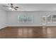 Bright, open living room with wood-look flooring, large windows, and a ceiling fan at 1099 Sandy Bank Ct, Auburn, GA 30011