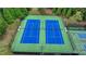 Night-lit tennis courts feature a green and blue color scheme and offer a fun activity at 1099 Sandy Bank Ct, Auburn, GA 30011