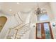 Foyer staircase with glass paneled wood doors, chandelier and arched window offering ample natural light at 2503 Regency Lake Dr, Marietta, GA 30062