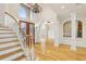 Elegant foyer with a staircase, chandelier, and views of the dining area and kitchen; featuring hardwood floors at 2503 Regency Lake Dr, Marietta, GA 30062