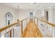 Open hallway with hardwood floors, white railing, arched doorways, and chandelier in a well-lit space at 2503 Regency Lake Dr, Marietta, GA 30062