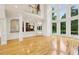 Bright and open living space featuring a view into kitchen, hardwood floors, fireplace, and large windows overlooking landscape at 2503 Regency Lake Dr, Marietta, GA 30062