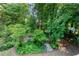 Lush backyard garden with mature trees, ferns and a small stone walking path at 3915 Woolbridge Way, Marietta, GA 30062