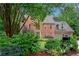 Beautiful brick house with lush front yard landscaping, a bench and a two-car garage at 3915 Woolbridge Way, Marietta, GA 30062