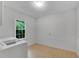 Bright laundry room features a window, light beige tile floor, and all-white walls at 3915 Woolbridge Way, Marietta, GA 30062