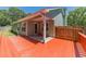 A cozy back porch with new wood flooring and a red railing opens to a fenced backyard at 647 New England Way, Lawrenceville, GA 30046