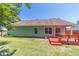 A spacious backyard features green grass, mature trees, and a cozy red porch at 647 New England Way, Lawrenceville, GA 30046