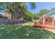 Large backyard featuring grass, mature trees, and a fenced in area with a red back porch at 647 New England Way, Lawrenceville, GA 30046