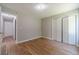 An empty bedroom features hardwood floors and a closet and a view of a hallway with white doors at 647 New England Way, Lawrenceville, GA 30046