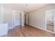 Bedroom with wood floors, closet with open doors, fresh paint and open doorway to the rest of the house at 647 New England Way, Lawrenceville, GA 30046