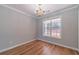 Elegant dining room features hardwood floors, chandelier lighting, and a large window with backyard views at 647 New England Way, Lawrenceville, GA 30046