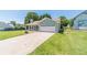 View of a blue single-Gathering home with a spacious driveway and an attached garage surrounded by green lawn at 647 New England Way, Lawrenceville, GA 30046
