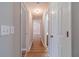 Hallway with wood floors, fresh paint, and multiple doors leading to various rooms in the home at 647 New England Way, Lawrenceville, GA 30046