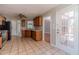 Bright kitchen featuring wooden cabinetry, tile floors, stainless steel appliances, and a door to the outside at 647 New England Way, Lawrenceville, GA 30046