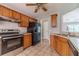 Kitchen featuring tile flooring, wooden cabinets, stainless steel appliances, and access to other rooms at 647 New England Way, Lawrenceville, GA 30046