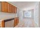 Kitchen with tile floors, wooden cabinets, stainless steel dishwasher, and breakfast nook with backyard views at 647 New England Way, Lawrenceville, GA 30046