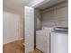 Convenient laundry area featuring washer, dryer, and shelving for organized storage solutions at 647 New England Way, Lawrenceville, GA 30046