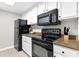 Kitchen view showcasing black appliances, white cabinets, and granite countertops at 1280 W Peachtree Nw St # 3208, Atlanta, GA 30309