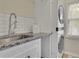 Laundry room featuring white subway tile, granite countertops, sink, and newer washer and dryer at 793 Fairington Pl, Lawrenceville, GA 30044