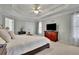 Bright main bedroom showcasing tray ceilings, large windows and neutral-colored carpet flooring at 793 Fairington Pl, Lawrenceville, GA 30044