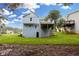 Back of a light blue two-story house featuring a deck, and a large grassy yard at 1139 Mainstreet Valley Dr, Stone Mountain, GA 30088